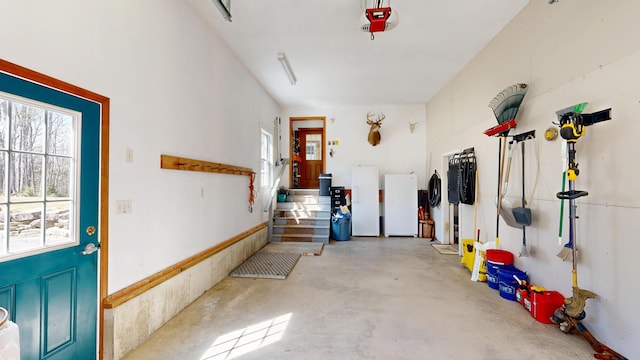 garage with freestanding refrigerator and a garage door opener