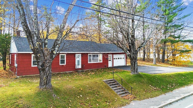 single story home with roof with shingles, driveway, a chimney, a garage, and a front yard