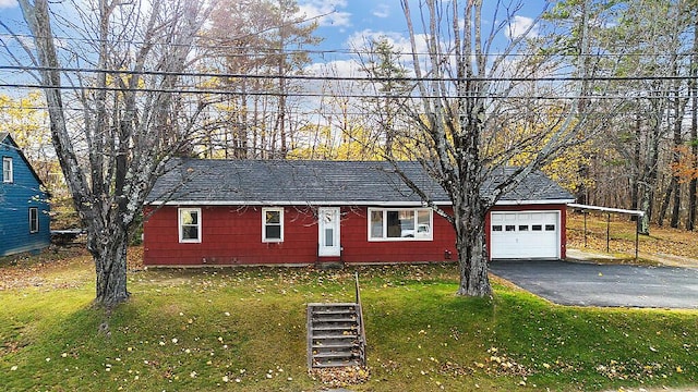 ranch-style home with driveway, roof with shingles, and a front yard