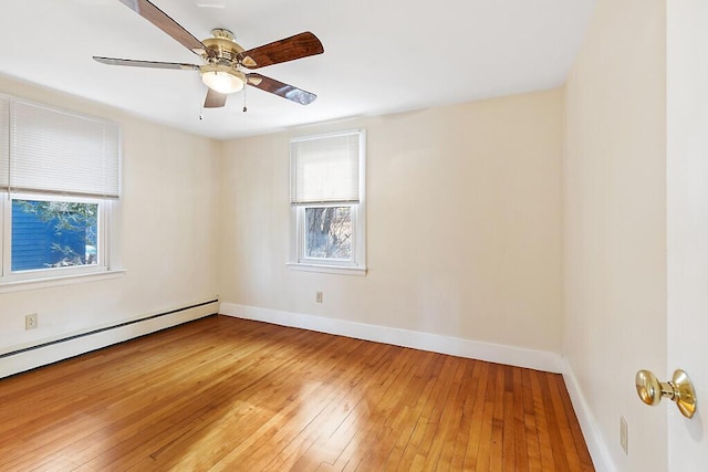spare room featuring a baseboard radiator, baseboards, ceiling fan, and light wood-type flooring