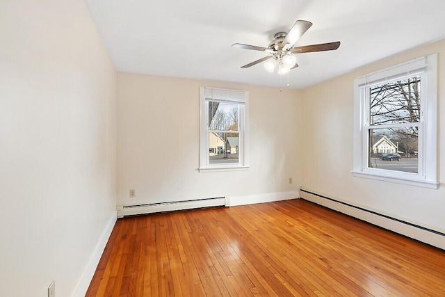 unfurnished room featuring a baseboard heating unit, light wood-style floors, and ceiling fan