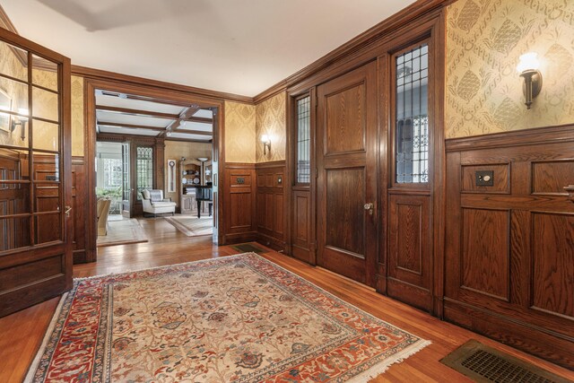 70 Carroll St, Portland, ME 04102 - foyer entrance with wallpapered walls, wood finished floors, wainscoting, and a decorative wall