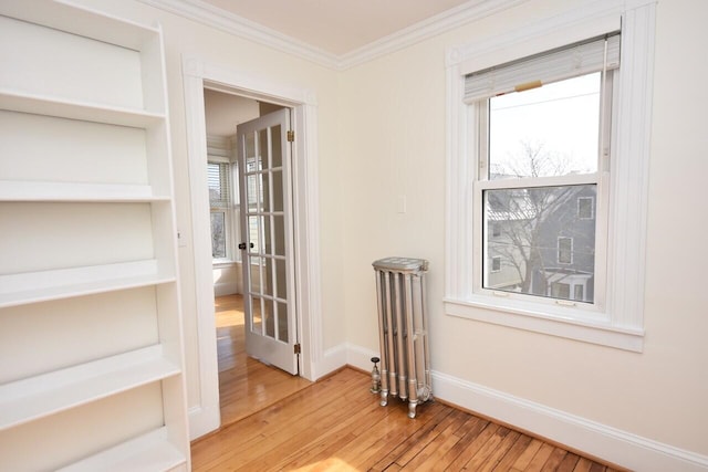 105 N St Unit 3, Portland, ME 04101 - unfurnished room featuring radiator heating unit, wood-type flooring, crown molding, baseboards, and healthy amount of natural light