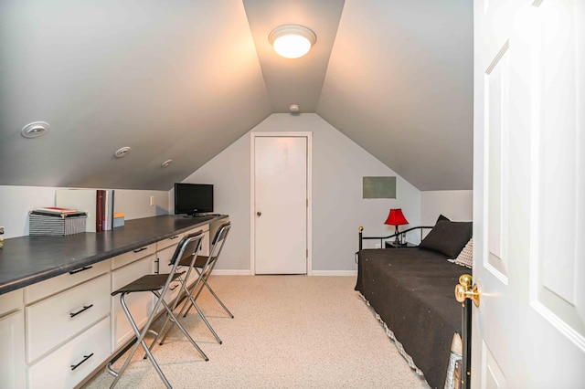 office featuring baseboards, lofted ceiling, and light carpet