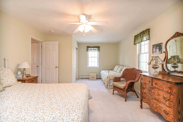 bedroom with ceiling fan, light carpet, baseboards, a baseboard heating unit, and a closet