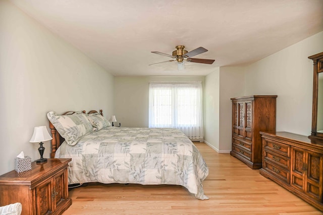bedroom featuring light wood-style floors, a ceiling fan, and baseboards