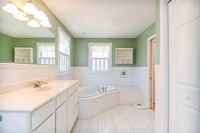 bathroom with a garden tub, tile patterned flooring, vanity, a wainscoted wall, and a notable chandelier