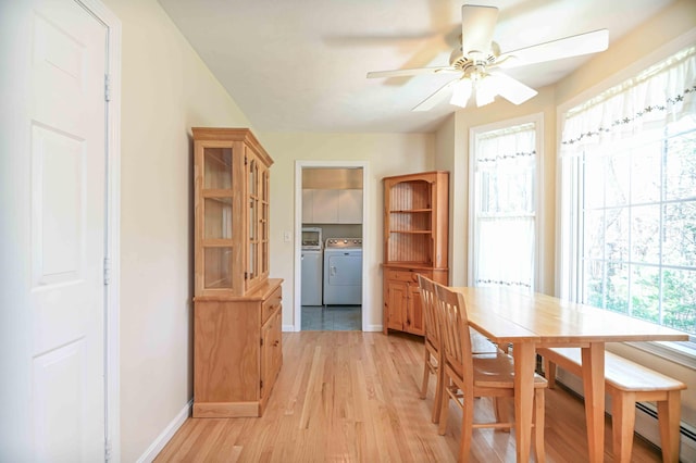 dining room with a ceiling fan, independent washer and dryer, baseboards, a baseboard radiator, and light wood finished floors