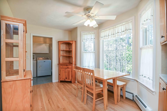 dining space with ceiling fan, a baseboard heating unit, washer and clothes dryer, and light wood-style floors