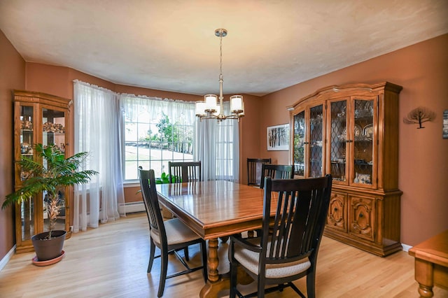 dining area with baseboards, a chandelier, baseboard heating, and light wood-type flooring