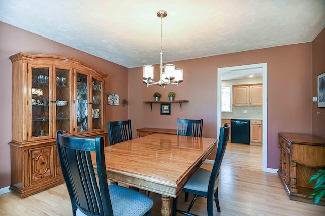 dining room featuring baseboards, an inviting chandelier, and light wood finished floors