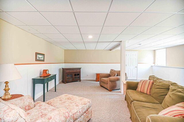 carpeted living room with a drop ceiling