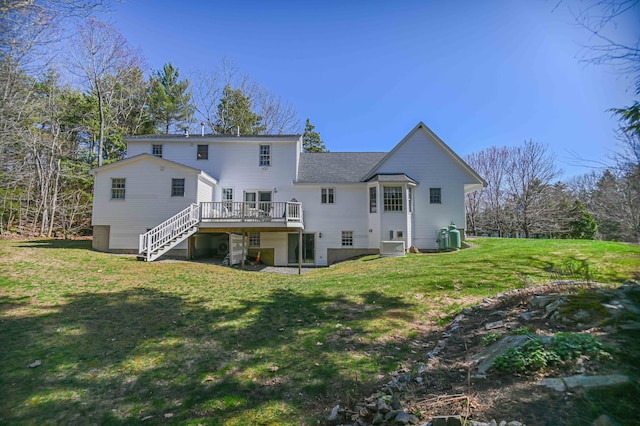 rear view of house with stairs, a wooden deck, and a yard