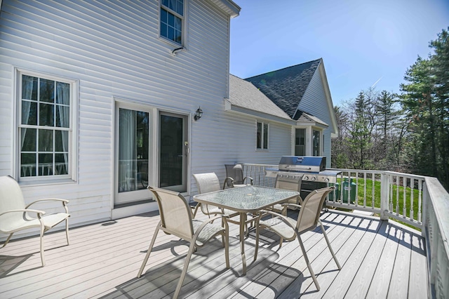 wooden terrace with outdoor dining area and grilling area