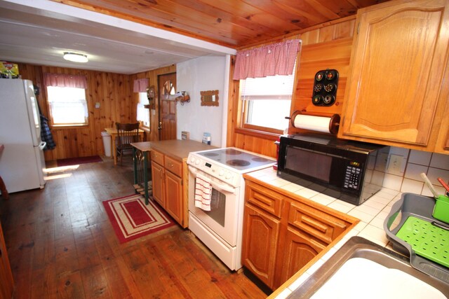 81 Shore Dr, Sabattus, ME 04280 - kitchen with white appliances, tile counters, dark wood finished floors, and wood walls