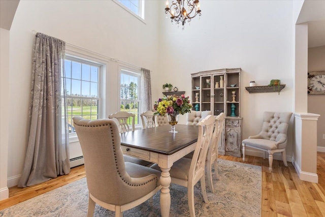 66 Grant Rd, Saco, ME 04072 - dining area featuring baseboards, a notable chandelier, plenty of natural light, and light wood-type flooring