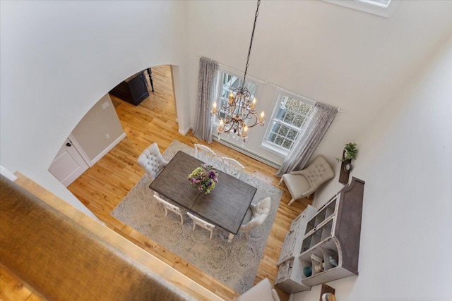 66 Grant Rd, Saco, ME 04072 - living room featuring arched walkways, a high ceiling, a chandelier, and wood finished floors