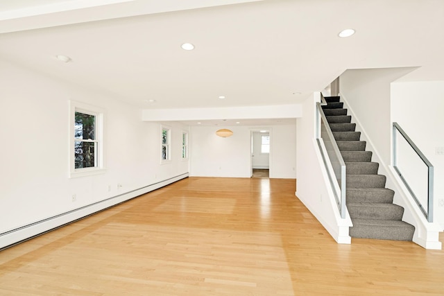 empty room featuring stairway, a baseboard radiator, light wood-style floors, and recessed lighting