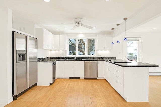kitchen with light wood-style floors, a peninsula, and stainless steel appliances