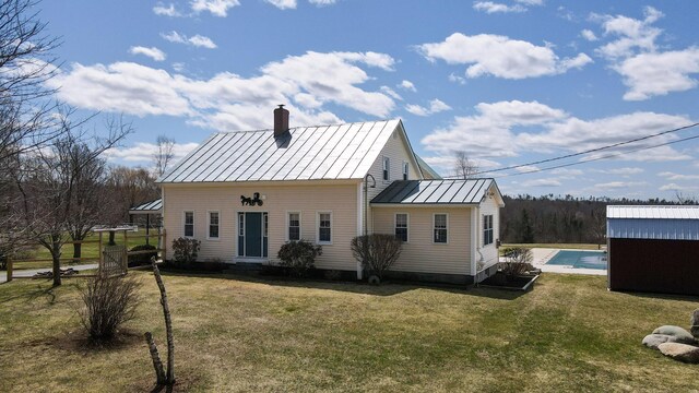 219 Middle Rd, Skowhegan, ME 04976 - rear view of property with a standing seam roof, metal roof, a chimney, an outdoor pool, and a yard