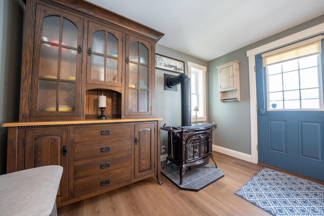 219 Middle Rd, Skowhegan, ME 04976 - foyer entrance featuring baseboards, light wood-style flooring, and a wood stove