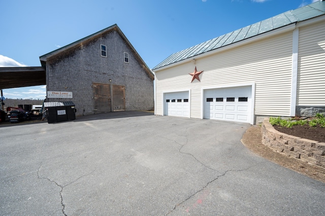 219 Middle Rd, Skowhegan, ME 04976 - view of property exterior with a standing seam roof, metal roof, a garage, and asphalt driveway