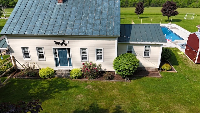 219 Middle Rd, Skowhegan, ME 04976 - view of front of house with a standing seam roof, metal roof, a front yard, an outdoor pool, and a chimney
