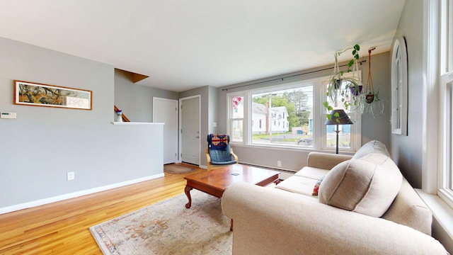 134 Saco St, Westbrook, ME 04092 - living area featuring a baseboard heating unit, wood finished floors, baseboards, and stairway