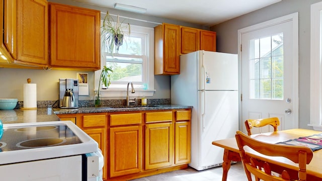 134 Saco St, Westbrook, ME 04092 - kitchen with white appliances, a sink, plenty of natural light, and brown cabinets