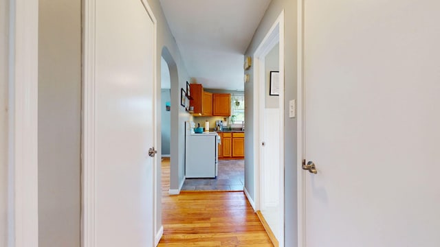 134 Saco St, Westbrook, ME 04092 - hallway with light wood-style flooring, baseboards, and arched walkways