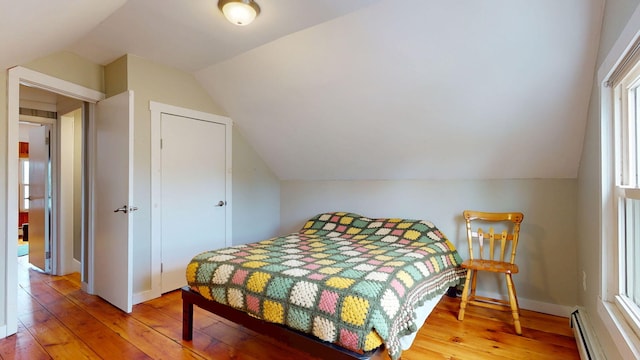 134 Saco St, Westbrook, ME 04092 - bedroom featuring a baseboard heating unit, vaulted ceiling, hardwood / wood-style flooring, and baseboards