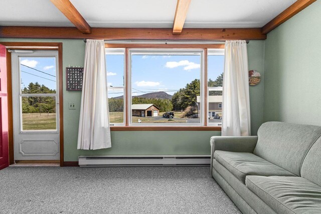 living area featuring a baseboard heating unit, beam ceiling, and carpet