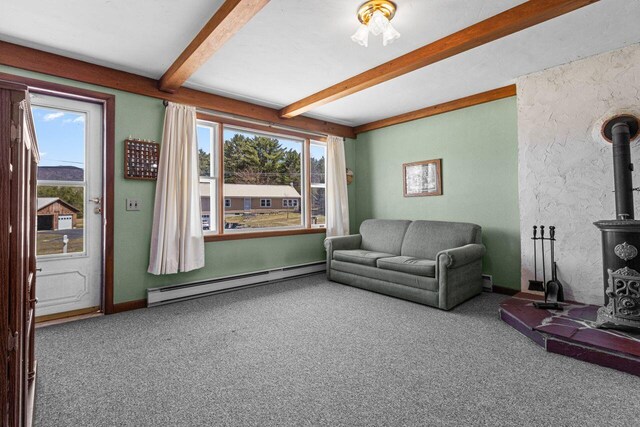 living area featuring beamed ceiling, a wood stove, carpet flooring, and baseboard heating