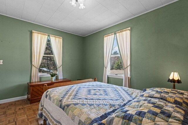 bedroom featuring crown molding, baseboards, and multiple windows