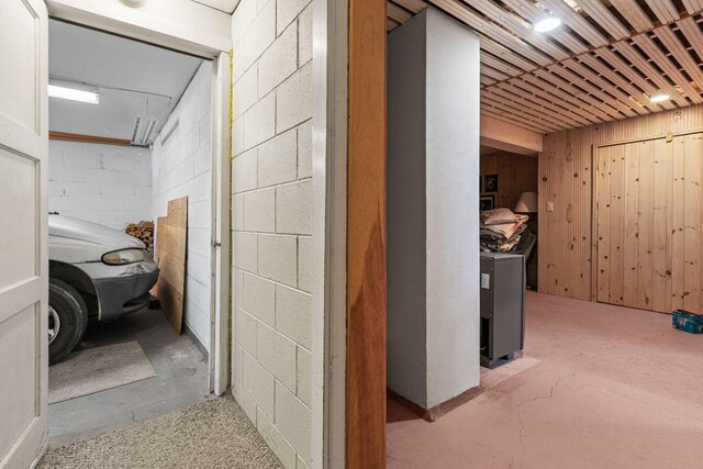 hall with concrete block wall and unfinished concrete flooring