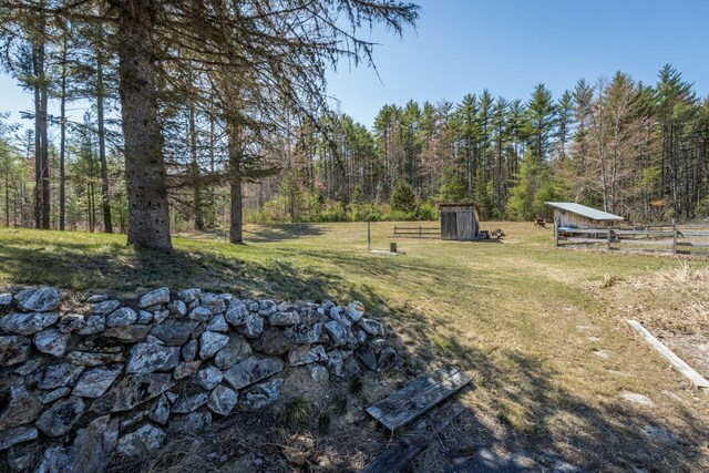 view of yard with fence and a wooded view