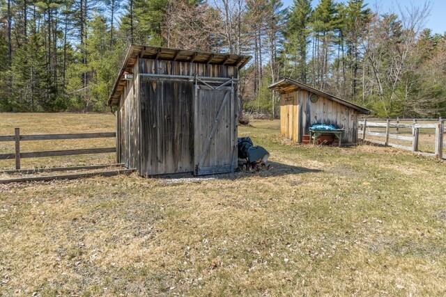 view of shed with fence and a wooded view