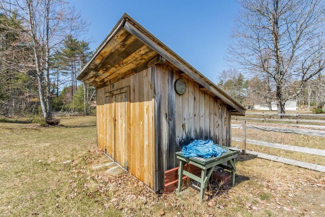 view of outbuilding featuring fence and an outbuilding