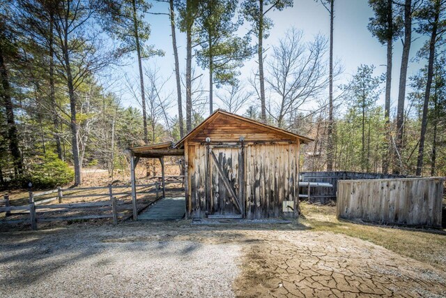 view of outbuilding with an outdoor structure and fence