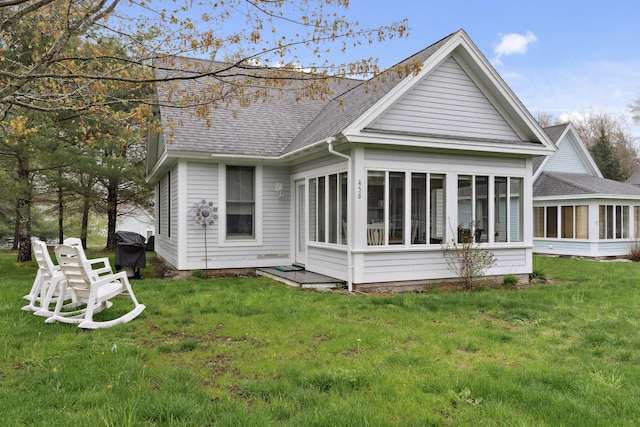454 Post Rd Unit 456, Wells, ME 04090 - rear view of house with a sunroom, a shingled roof, and a lawn