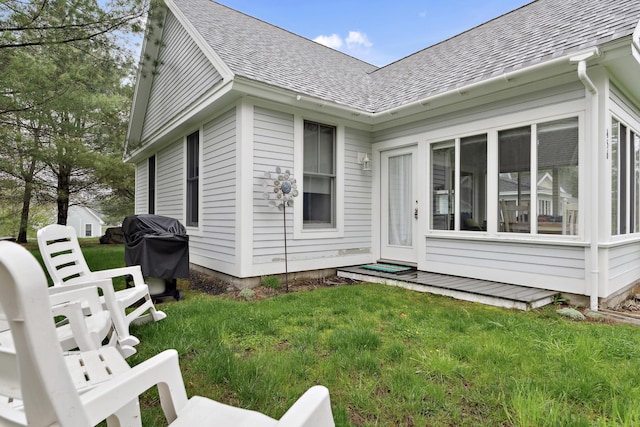 454 Post Rd Unit 456, Wells, ME 04090 - rear view of house featuring roof with shingles, a lawn, and a sunroom