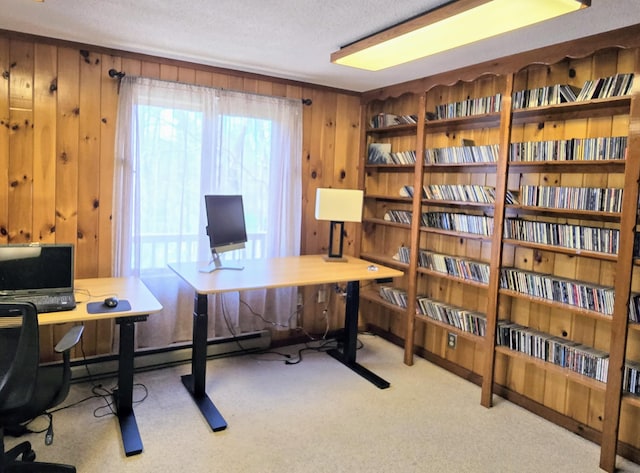 carpeted office featuring a textured ceiling and wooden walls