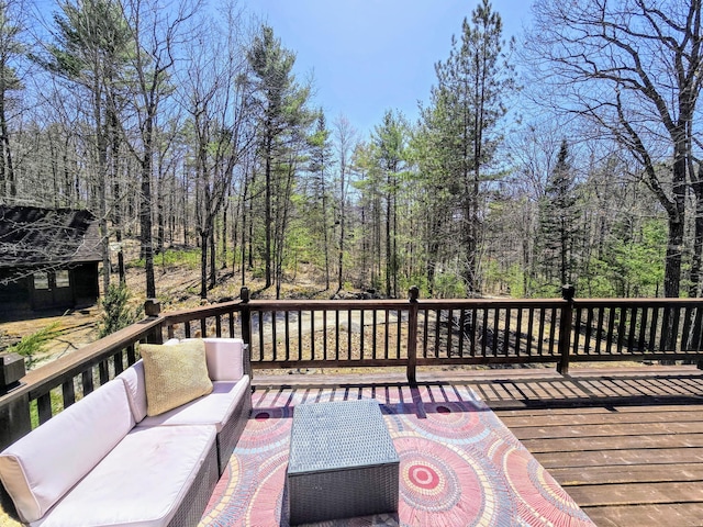 deck featuring outdoor lounge area and a forest view