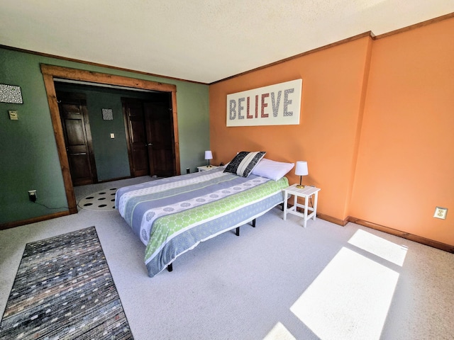 bedroom with baseboards, ornamental molding, and carpet