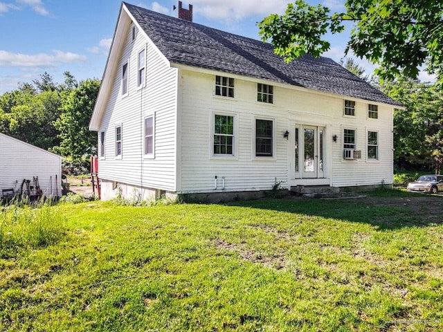 exterior space with a front lawn, a chimney, and cooling unit