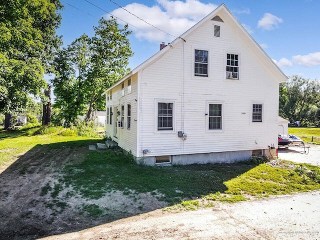 view of side of home with a yard