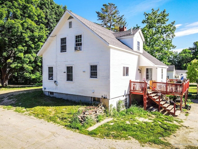 exterior space with a wooden deck, a yard, and stairs