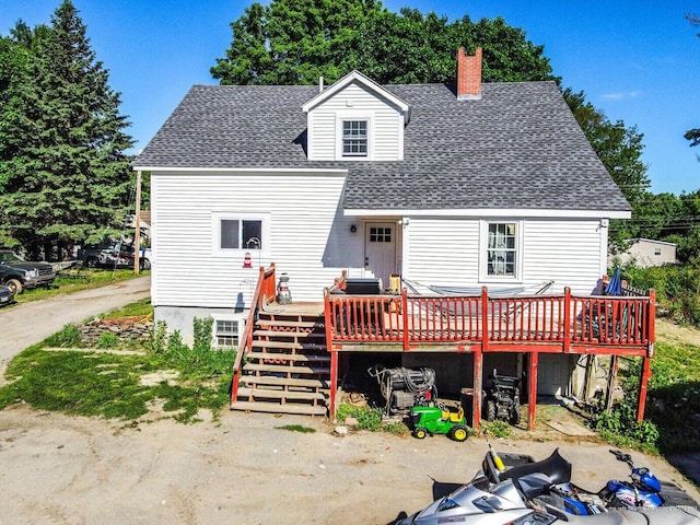back of house featuring a wooden deck, a shingled roof, a chimney, and stairs