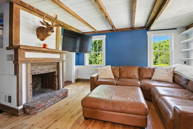 817 Riverside Dr, Augusta, ME 04330 - living area featuring beam ceiling, wood-type flooring, and a brick fireplace