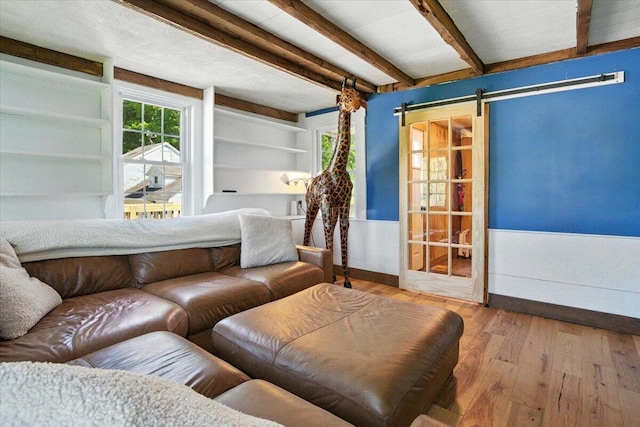 817 Riverside Dr, Augusta, ME 04330 - living area with hardwood / wood-style floors, beam ceiling, and a barn door